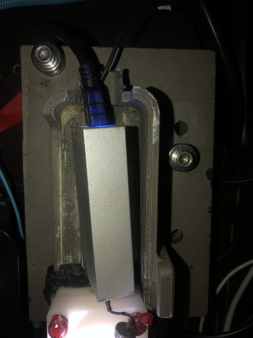 Silver aluminium EDR4 amplifier box with a blue-lit USB cable clamped in a 3D-printed bracket over a white flow cell with red wing nuts.