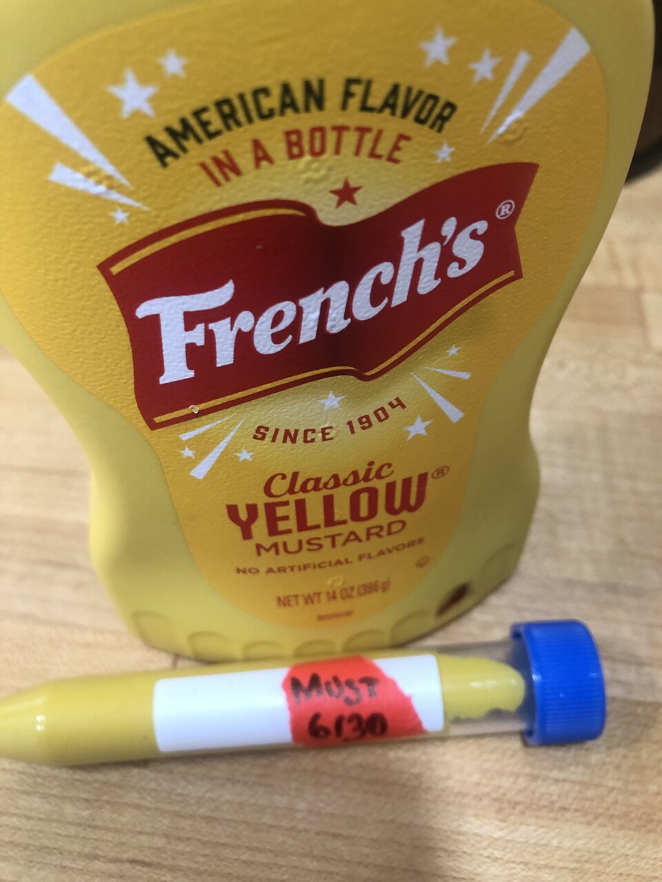 Bottle of French's classic yellow mustard with a labelled sample tube in front.